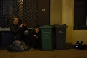 People take cover and photos near the Bataclan concert hall in central Paris, on November 13, 2015. A number of people were killed and others injured in a series of gun attacks across Paris, as well as explosions outside the national stadium where France was hosting Germany. AFP PHOTO / DOMINIQUE FAGET