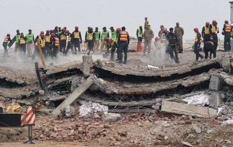 Pakistani rescuers search for victims in the rubble of a collapsed factory on the outskirts of Lahore on November 5, 2015. Pakistani rescuers have pulled 99 people out alive from the rubble of a collapsed factory and are searching for an unknown number of others believed still trapped in a disaster that has killed at least 18, officials said. AFP PHOTO / ARIF ALI