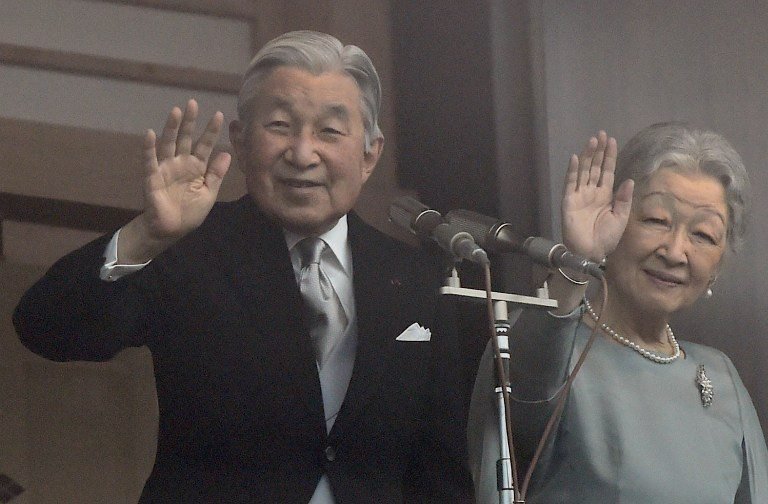 Japanese Emperor Akihito (L) and Empress Michiko (R) wave to well-wishers from the balcony of the Imperial Palace in Tokyo on December 23, 2015. Thousands of people gathered at the palace to celebrate Emperor Akihito's 82nd birthday. AFP PHOTO / TOSHIFUMI KITAMURA / AFP / TOSHIFUMI KITAMURA