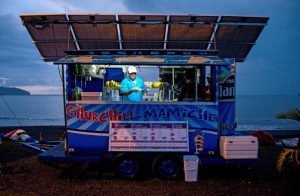 A customer buys ice-cream at night at the Churchill Mamiche ice-cream parlour on October 31, 2015, in Caldera, Puntarenas, 80 km southwest of San Jose. The Churchill Mamiche ice-cream parlour is entirely powered --day and night-- by solar panels. By means of energy generated by its rivers, volcanos, wind and sun, Costa Rica aims to get this year up to 97.1 % of its electricity from renewable sources. AFP PHOTO / Ezequiel BECERRA